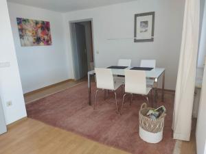 una sala da pranzo con un tavolo e sedie bianche di Ferienwohnung Josi a Heidenheim an der Brenz