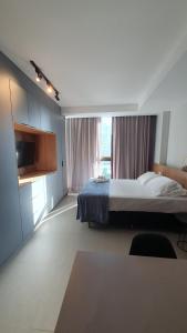 レシフェにあるRooftop 470 #Flat 401 - Boa Viagemのベッドと大きな窓のある寝室