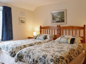 a bedroom with two beds and a window at Bridge Cottage in Braithwaite