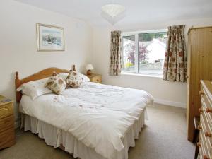 a bedroom with a bed and a window at Bridge Cottage in Braithwaite