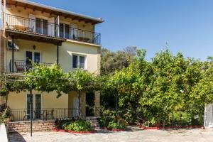 an apartment building with trees in front of it at Kefalas Apartments in Parga