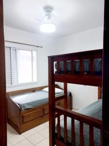 a bedroom with two bunk beds and a window at Apto Pé na Areia com Vista Mar, Churrasqueira e Espaço para 8 Pessoas in Praia Grande +13 photos