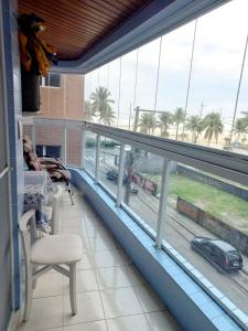 Habitación con balcón con vistas a la calle. en Apto Pé na Areia com Vista Mar, Churrasqueira e Espaço para 8 Pessoas, en Praia Grande