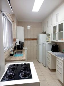 Una cocina con un horno de estufa en una cocina en Apto Pé na Areia com Vista Mar, Churrasqueira e Espaço para 8 Pessoas, en Praia Grande