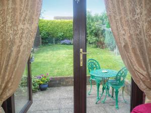 an open door to a patio with a table and chairs at White Cottage in Hemingby