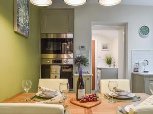 a dining room with a table with wine glasses at Rydal Cottage in Bowness-on-Windermere