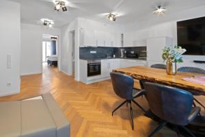 a kitchen with white cabinets and a wooden table and chairs at Luxus im Zentrum für 6 Personen! 3 Zimmer, Balkon, WLAN, Parkplatz in Dresden +39 photos