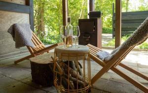 two rocking chairs and a table with a wine glass at Cabin La Luna in Kats +3 photos