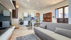 a living room with a couch and a kitchen at Appartamento Cinisi in Cinisi