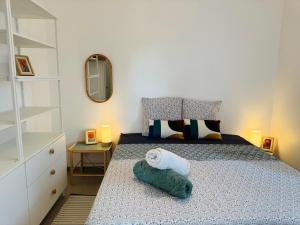 a small bedroom with a bed and a mirror at L'escapade Landaise à 10 minutes des plages in Soustons