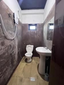 a small bathroom with a toilet and a sink at Rustique House dbl in Nuwara Eliya