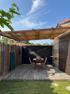 a patio with a table and chairs under a pergola at L'escapade Landaise à 10 minutes des plages in Soustons