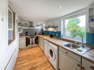 una cocina con fregadero y lavavajillas en Swinton Mill Farm Cottage, en Duns