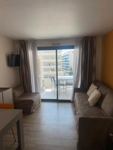 een woonkamer met een bank en een stoel en een balkon bij CANNES Palazzio in Cannes