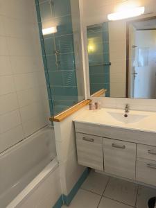 een badkamer met een wastafel, een spiegel en een bad bij CANNES Palazzio in Cannes +44 foto's