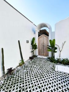 a door in a room with plants on the floor at Villa Chioni Uluwatu by LODGELINK BALI in Uluwatu