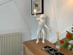 a statue of a person holding a light on a table at Winkle Cottage in Calbourne