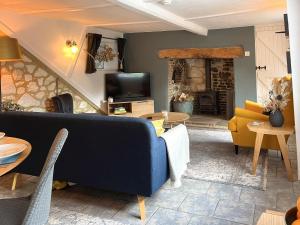 a living room with a couch and a fireplace at Winkle Cottage in Calbourne