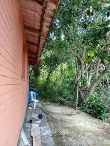 a porch of a house with a table and a chair at Chácara Encanto do Luar casa de 2 quartos in Rio Bonito