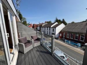 a balcony with two chairs and a view of a street at SmithStayz Poulton in Poulton le Fylde