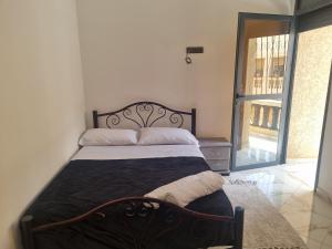 Una cama en un dormitorio con una ventana grande. en Bouztour, en Bouznika
