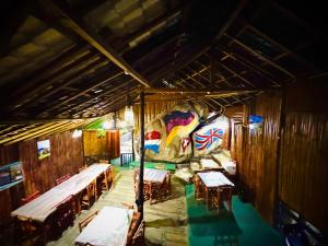 a room with tables and a large painting on the wall at Ravana Falls Resort in Ella