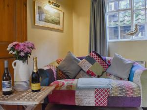 ein Wohnzimmer mit einem Sofa und einer Flasche Wein in der Unterkunft Oakfield Cottage in Robin Hood's Bay