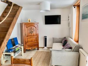 a living room with a couch and a tv at Charmante maison à Jard sur mer sur la côte vendéenne in Jard-sur-Mer