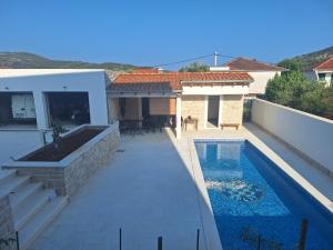 a backyard with a swimming pool and a house at Apartmani Jerka in Vinišće