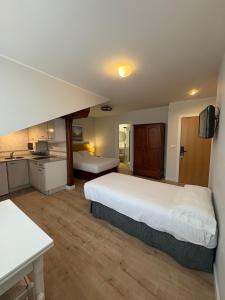 a large bedroom with two beds and a kitchen at Hotel Puerto de Llanes in Llanes