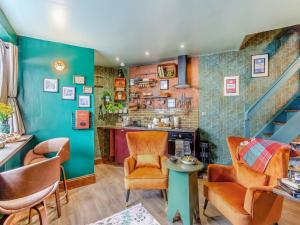 Una sala de estar con escalera y sillas. en Buttress Retreat, en Hebden Bridge