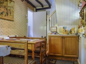 eine Küche mit einem Holztisch und einer Theke mit Stühlen in der Unterkunft Tudor Cottage in Bidford