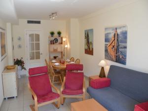 a living room with a table and a blue couch at Estartit Park PB-1 in Torroella de Montgrí