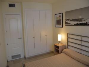 a bedroom with a bed and a closet and a lamp at Estartit Park PB-1 in Torroella de Montgrí +15 photos