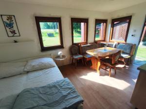 una camera da letto con un letto, un tavolo e delle sedie di Lesní chaty "Hogo Fogo" a Kytlice