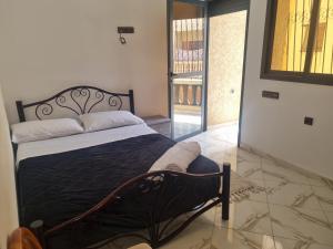 Un dormitorio con una cama con marco de cama negro. en Bouztour, en Bouznika
