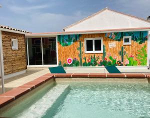 a house with a swimming pool in front of a mural at Gite Blanco y Madera in Narbonne