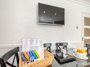 a dining room with a table and a television on a wall at Duck Bay Cottage 1 - Uk43934 in Balloch
