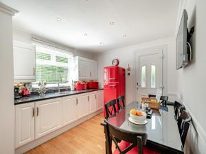 a kitchen with a red refrigerator and a table at Duck Bay Cottage 1 - Uk43934 in Balloch