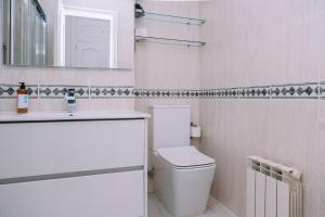a white bathroom with a toilet and a sink at Con encanto en el centro de Vigo by CABANA Rentals in Vigo +15 photos