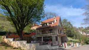 a large house with a balcony and a tree at Chambres d'hotes la forêt in Longwy