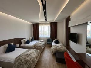 a hotel room with two beds and a couch at Apel Luxury in Niš +73 photos