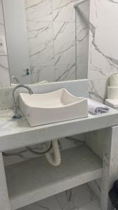 lavabo blanco en la encimera del baño en HOTEL FÊNIX, en Campina Grande