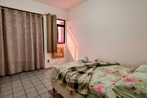 ein Schlafzimmer mit einem Bett und einem Fenster in der Unterkunft PRAIA POÇO, 150m do mar, piscina, 5 pes, 3 quartos in Ilha da Restinga + 16 Fotos