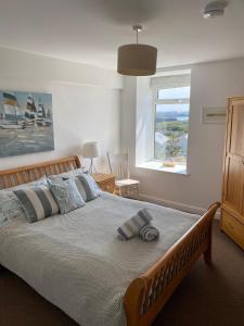 a bedroom with a large bed with a large window at Tudor Apartment (Panoramic Sea Views) in Trearddur