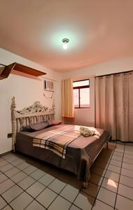 ein Schlafzimmer mit einem großen Bett in einem Zimmer in der Unterkunft PRAIA POÇO, 150m do mar, piscina, 5 pes, 3 quartos in Ilha da Restinga