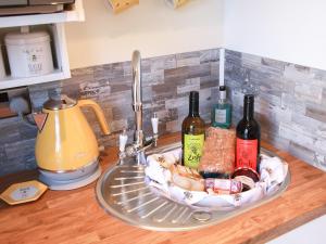 a tray with bottles of wine sitting on a kitchen sink at The Beehive in Mundesley +12 photos