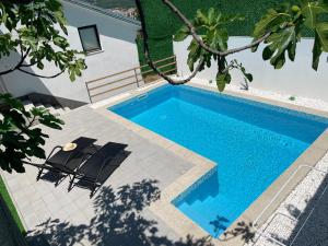 an image of a swimming pool with chairs next to a house at Hills Holiday House in Mostar