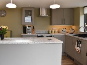 a kitchen with gray cabinets and a counter top at The Bothy in Beetham +15 photos