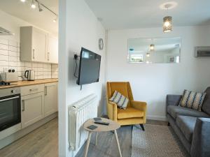 Il dispose d'une cuisine et d'un salon avec un canapé et une table. dans l'établissement Coley Cottage, à Wainfleet All Saints